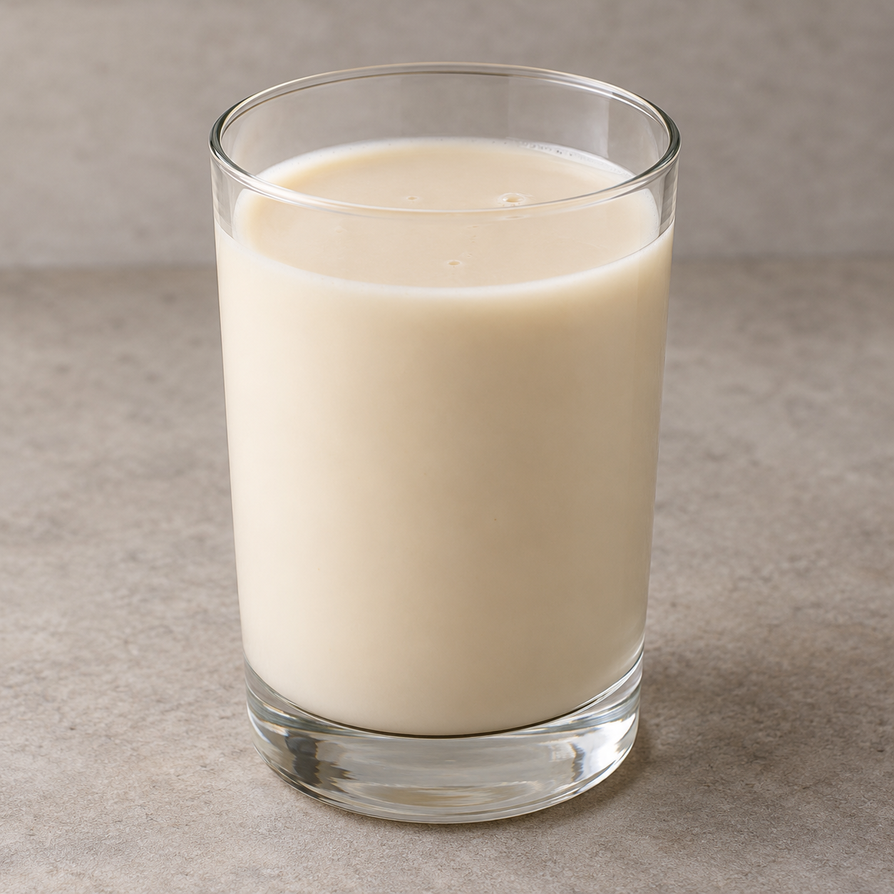 A plain glass of smooth pale ivory Kunun Aya tiger-nut drink.