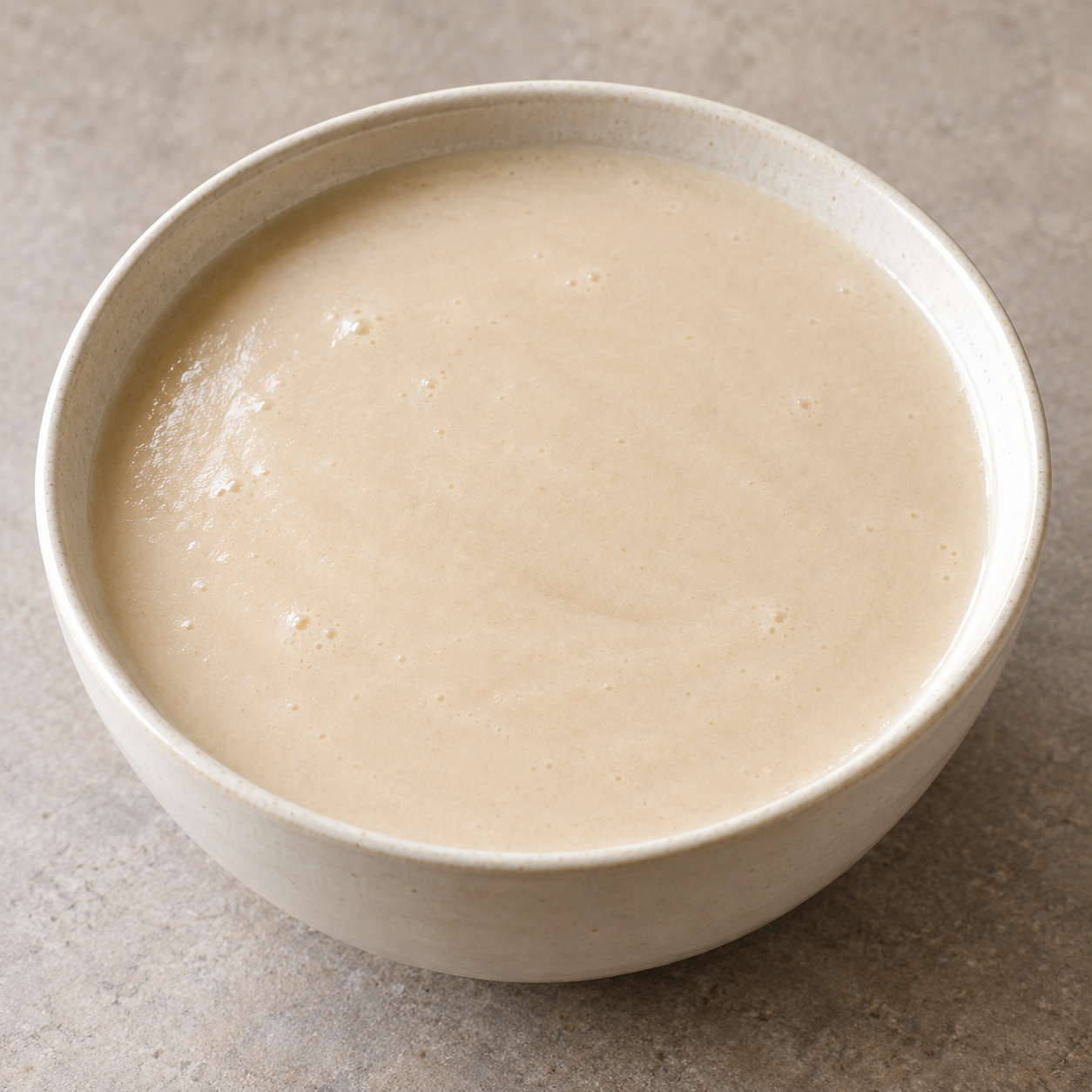 Kunun Gyada, a smooth pale groundnut-and-rice gruel in a plain bowl.