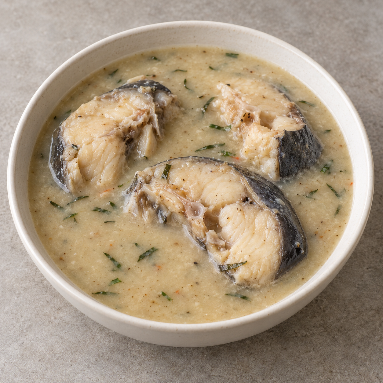 Pale Ofe Nsala with cooked grey-skinned catfish steaks and sparse fine utazi leaf slivers.