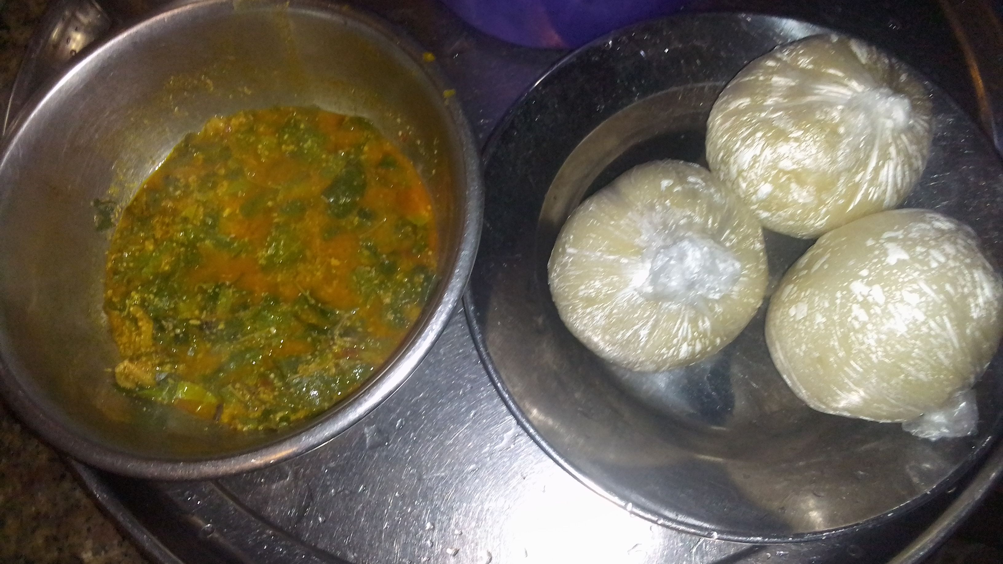Wrapped akpu cassava-fufu portions with oha soup alongside