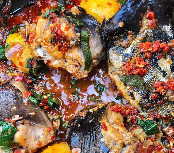 Catfish pepper soup with chunky garnish and yellow starchy pieces
