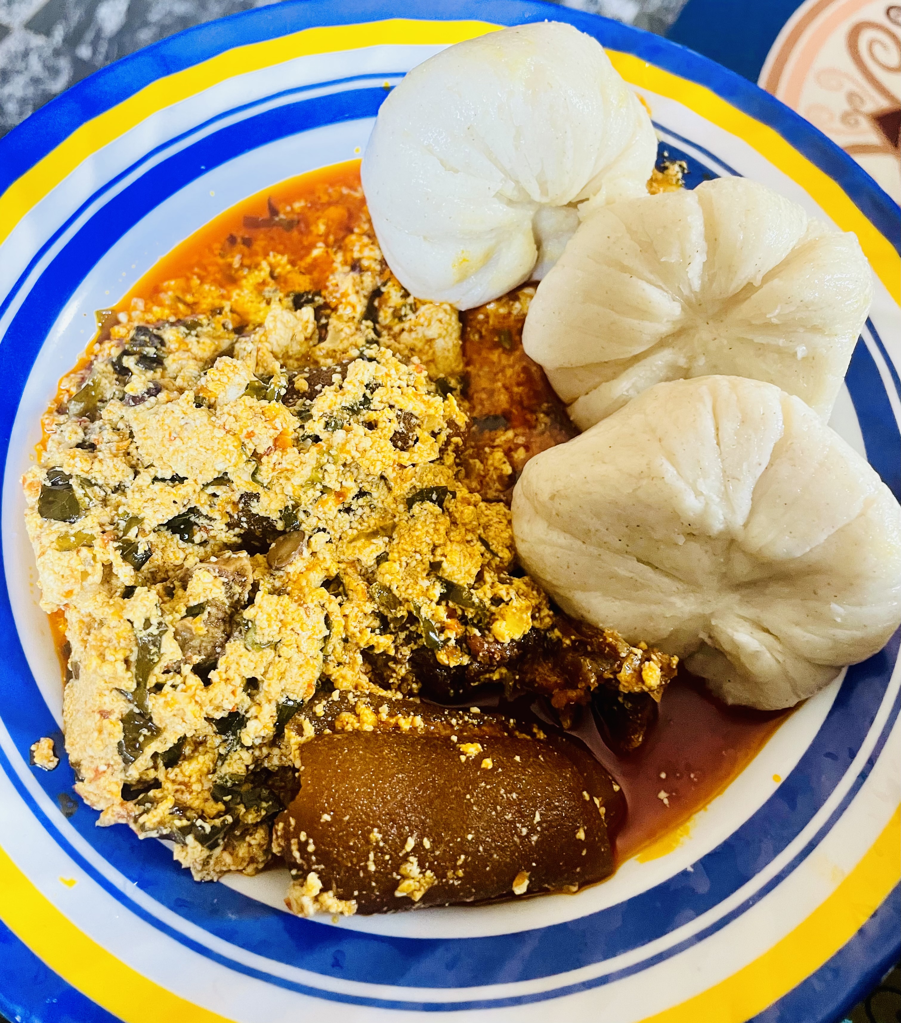 Egusi soup with leafy greens and meat, served with swallow
