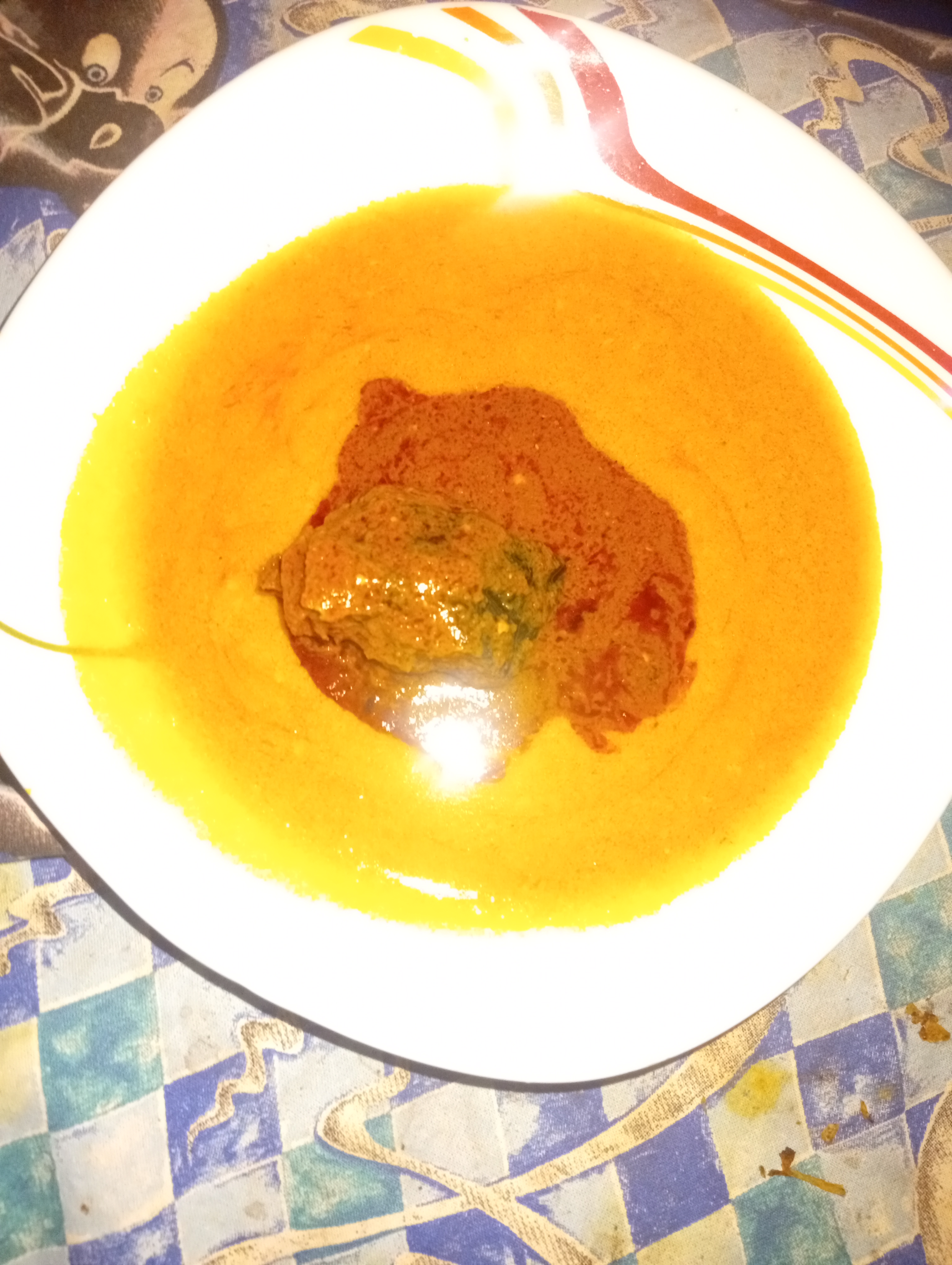 Smooth golden gbegiri with a red stew and meat topping