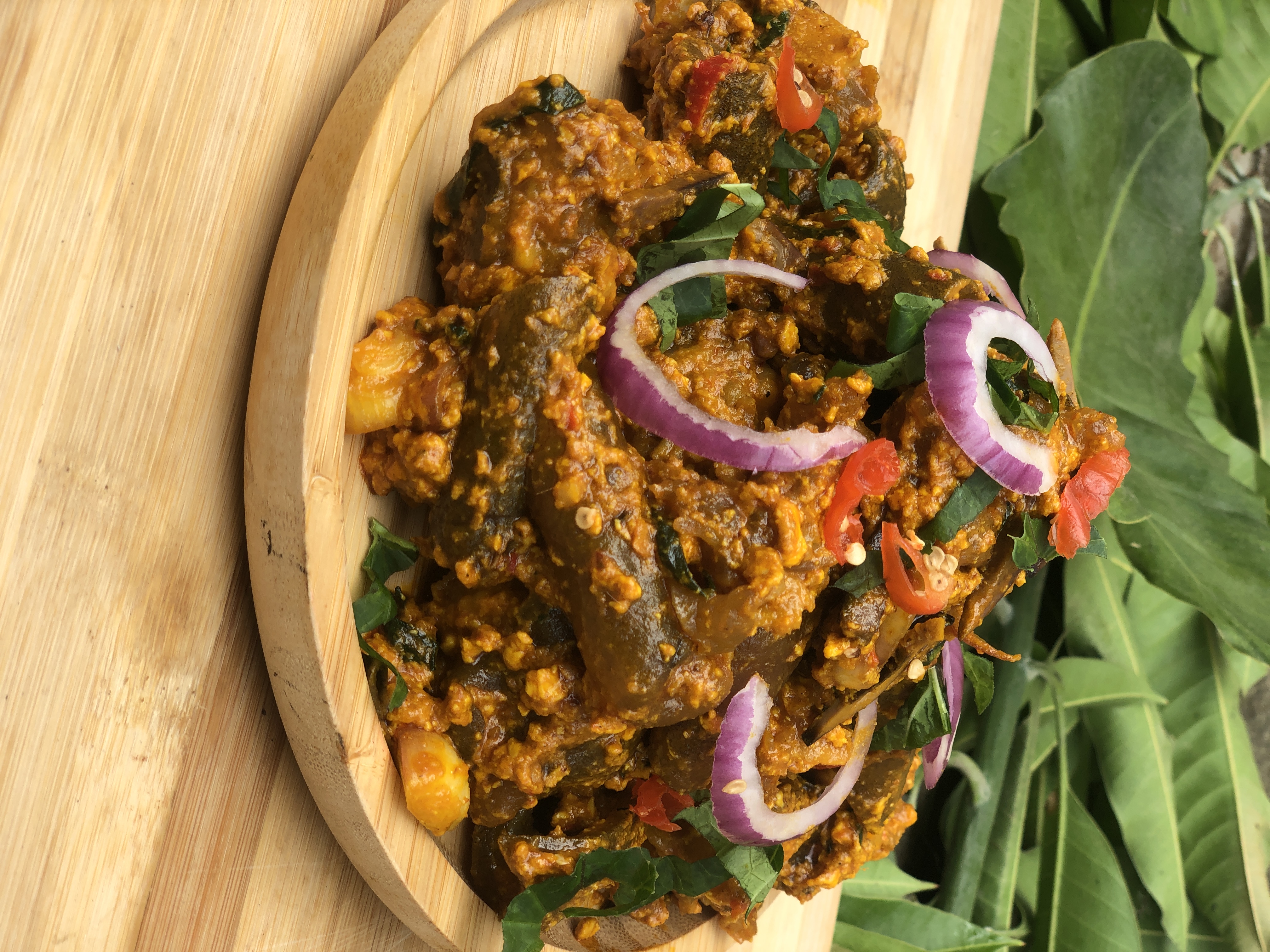 Nkwobi cow-foot pieces with orange dressing, onion and leaves