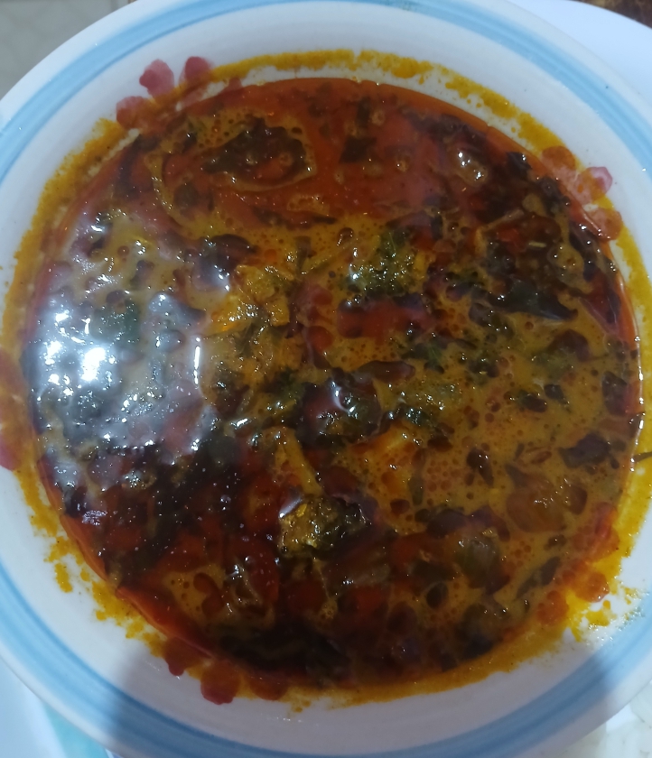 Ofe akwu palm-fruit stew with meat and leafy herbs