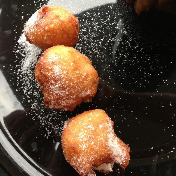 Sugar-dusted puff puff on a dark plate